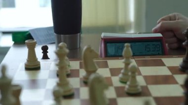 Satranç tahtası stratejik oyun için yerleştirilmiş parçalarla oyun ortası senaryosunu gözler önüne seriyor. Sonraki hamleyi düşünmek için harcanan zaman saate göre sayılıyor