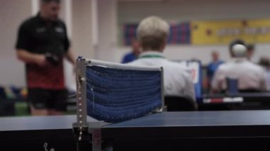 Tenis topu, özel odada masa tenisi oynarken ağın üzerinden uçar. Formda kalmak için aktif katılımcı sporlar kavramı