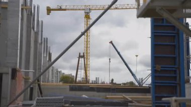 Büyük vinç ve beton yapılarla sağlam temeller. Çelik takviye birlikleri ve ekipmanlar inşaatın ilk aşamalarını gösteriyor