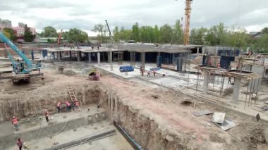Metro istasyonunun inşaat alanında çeşitli işlerde çalışan işçiler var. Site özellikleri beton yapılar ve kazı alanlarını güçlendirdi