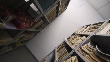Müzik teorisi ve tarih kitapları okul kütüphanesindeki uzun metal rafları düzgünce doldurur. Her kitap müzik sanatında değerli bir rehber görevi görüyor.