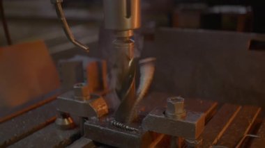 Matkap, duman ve enkaz yayarken metaldeki deliği güvenli bir şekilde sıkıyor. Yoğun süreç endüstriyel gücün iş başında olduğunu ortaya koyuyor. Metal işleme