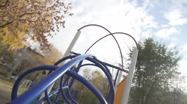 Modern oyun alanı ekipmanları uzun ağaçların gölgesinde dinlenir. Yakınındaki kuşlar canlılığı ve doğayla bağlantıyı artırır. Sessiz ortama hareket katar.