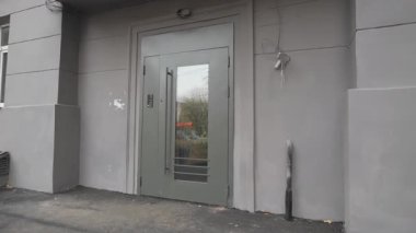 Nötr renklerle ve basit çizgilerle çerçevelenmiş cam ön kapı. Düzen, iş ziyaretçilerine güvenli erişimin yanı sıra berraklığı da vurguluyor