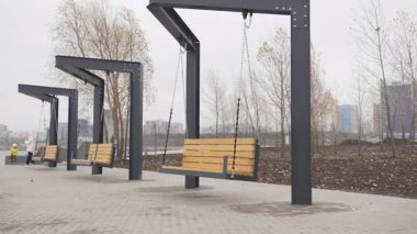 Sallanan banklar park yolu boyunca sağlam zincirlerden sarkıyor. Eşsiz koltuklar yaya bölgesine oyuncu hareketler ekler ve ziyaretçiler için etkileşimli dinlenme yerleri sunar