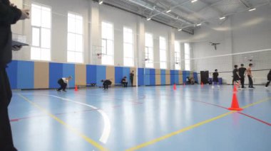 ALMATY, KAZAKHSTAN - 19 Mart 2025: Beden eğitimi dersi yoğun mekik koşusunu içeriyor. Çocuklar koniler arasında koşar refleksleri ve kardiyovasküler dayanıklılığı arttırır