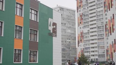 ALMATY, KAZAKHSTAN - 19 Mart 2025: yüksek binalar arasında bulunan okul tesisi. Lyceum 'un modern tasarımı, yoğun ortamlarda okul faaliyetlerini destekler