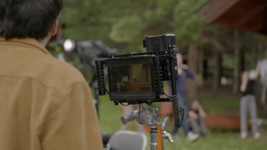 ALMATY, KAZAKHSTAN - AĞUSTOS 05 2024: Yorgun aktörler, yönetmen notlar verirken kamera önünde dinlenirler. Yaratıcı ayarlamalar için kısa bir duraklama. Enerji uzun çekim boyunca dengelendi