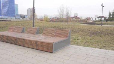 Şık banklar asfaltlı park yolunu sanatsal hassasiyetle hizalıyor. Kıvrımlı şekiller modern dinlenme bölgeleri yaratır. Kamu tasarımı kasıtlı hissettiriyor