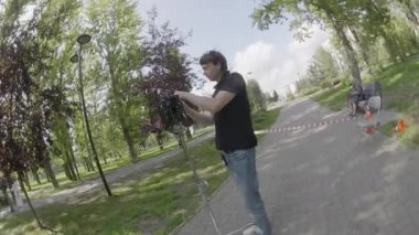 ALMATY, KAZAKHSTAN - AĞUSTOS 07 2024: film çekimi. Adam profesyonel Steadicam kurulumunu parktaki film setine ayarlıyor. Ekip arka planda ekipman hazırlar ve düzenler