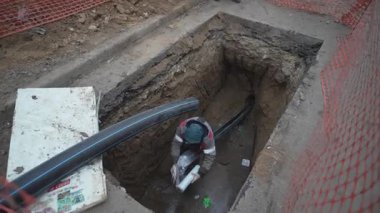 Ağ ile çevrili kanalizasyon çukuru yeni kurulmuş drenaj makineleri içeriyor. Kalifiye işçi sistemi en uygun akış için dikkatlice düzenler