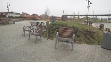 Paved banliyö sokağı sessiz patika boyunca düzgün banklarla uzanıyor. Sıcak yerler barışçıl yürüyüşler gerektirir. Yol zarafet ve faydayı harmanlıyor