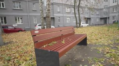 Sonbahar, çok katlı binanın soluk cephesinin yanında battaniye gibi sessiz bir bank bırakır. Çıtır çıtır kuru yapraklar yerleşim yerine sıcaklık katıyor