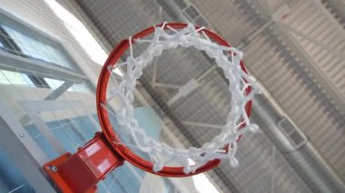 Basketbol potası spor salonunda asılı duruyor. Metal tavan ve büyük cam pencereler yeni spor salonu içinde endüstriyel spor ortamı oluşturuyor