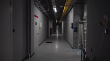 Düşük tonlu ve lambalarla aydınlatılan elektrik santralinin koridoru. İşletim güvenliği ile verimli navigasyon tasarımı teşvik eder