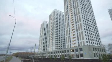 Yüksek apartman yapısı, geometrik hassasiyetle gösterilen zarif estetiğin üzerinde yükselir. Binalar çağdaş metropol genişlemesini temsil ediyor