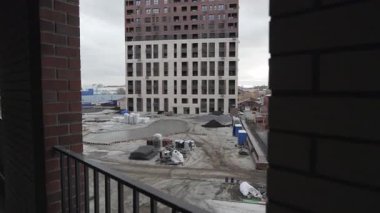 İnşaat alanında makineli ile bitirilmemiş yüksek katlı bir bina. Çağdaş konut kompleksinin toprakları üzerinde yeni binaların geliştirilmesi