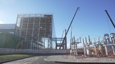 Elektrik santrali manzarası, dağıtım ünitesi yakınındaki inşaat alanı ve vinçleri kaldırma. Enerji altyapısı gelişimi