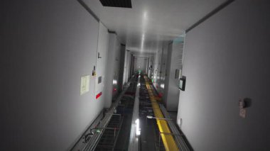 Kamera, elektrik santralinin sessiz koridorunda sorunsuzca süzülüyor. Serin ışıklandırma ve minimalist tasarım steril endüstriyel atmosfer yaratır