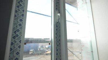 Plastik kapaklı yeni pencere aktif inşaat alanının panoramik görüntüsünü sunuyor. Şeffaf bariyer içeriyi korurken berraklığı korur