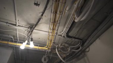 Çelik ağ kanal sisteminde tavanda kalın kablo yılanları var. Profesyonel elektrik tesisatı dikkatli kablo yönetimini gösteriyor