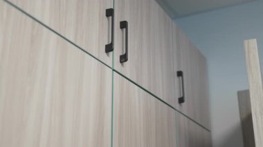 Ahşap dolap kapıları minimalist öğrenci odasına sıcaklık katar. Doğal dokular konforlu işlevsel atmosfer ve temiz estetik cazibe zenginleştirir