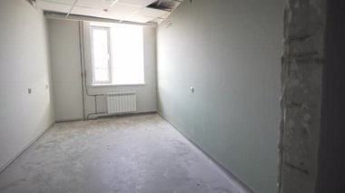 Büyük ham oda, inşaat alanı manzarası sunan geniş pencereleri de içeriyor. Modern radyatörler uzun şeffaf pencerelerin altında düzgünce otururlar.