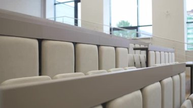 Sağlam çerçeveli rahat yumuşak sandalyeler modern oditoryum tasarımını tamamlıyor. Düzenleme net görüş açılarını ve ulaşılabilir koridorları teşvik eder