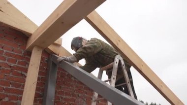 ALMATY, KAZAKHSTAN - 19 Şubat 2025: Kaynak kalın demir kirişleri sağlam bir çerçeve oluşturur. Isı metal bağlayıcı elementleri pürüzsüz eritiyor. Parlak kıvılcımlar ritmik patlamalarla uçuşuyor