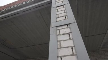 Metal çubuklarla güçlendirilmiş tuğla sütun verandayı destekliyor. Yapısal dayanıklılık sağlam kavşakta görülebilir. Kombinasyon istikrarı sağlar