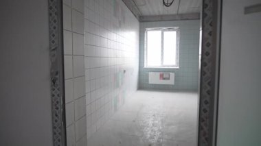 Döşemeli oda, temiz duvarlardan elektrik kabloları çıkan aletleri bekliyor. Keskin geometri şekilleri steril yapıyı oluşturur. Kompakt oda eşyalar bekliyor.