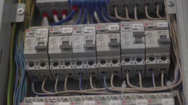 Elektrik santrali parlayan anahtarlarla aydınlatılan test modunda açık duruyor. Elektrikçi yüksek voltajlı bağlantıları dikkatle denetliyor