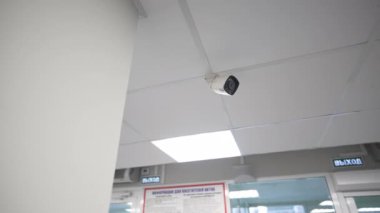 Güvenlik kamerası ofis merkezinin tavanındaki hareketliliği kaydediyor. Modern güvenlik ekipmanları kamu tesisinde video kontrolü sağlıyor