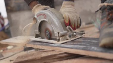 İnşa kılavuzu kalın ahşap tahtada dönen testere bıçağı. Keskin bıçak düzgün bir çizgi oluşturur. Keskin bir kesim tahtası.