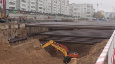 ALMATY, KAZAKHSTAN - 17 Ekim 2024: Kazıcılar boru hattı sistem onarımı için toprağı kazıyorlar. Şehir bloğundaki makinelerle kentsel altyapı ve kamu hizmetleri geliştirme