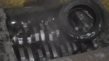 Donmuş lastikler donuk gümbürtüyle dönen öğütücü bağlantılarına çarpıyor. Modern makineler kullanılarak lastiklerin hammaddeye dönüştürülmesi