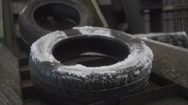 Fabrika işçisi donmuş katı lastikleri kasıtlı olarak yüksek soğuk dikey taşıyıcıya yerleştirir. Donmuş sessizlik eldiven hareketlerini sarar