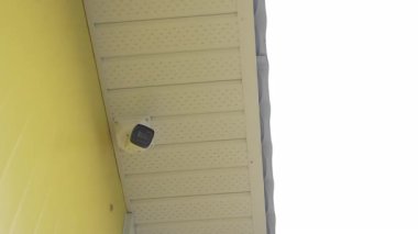 Sayısal CCTV kameraları çatı katının dışında düşük açılı çekim yapıyor. Güvenlik ekipmanları kasvetli gökyüzü altındaki binanın videosunu kaydediyor.