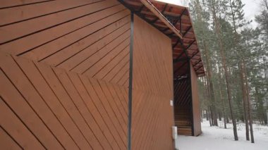 Eğlence köşkünün ahşap duvarları karlı çam ormanlarıyla doğal olarak harmanlanır. Buz altında her ışık huzurlu görünüyor. Bu da konforu gösteriyor.