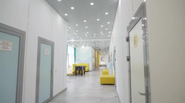 Masa başı futbol ve kanepeleri olan boş çocuklar için tıp merkezi salonu. Parlak ışıklandırılmış eğlence merkezi lobisi. Koltukları ve cam duvarı var.