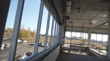 Tamamlanmamış iskeletler boş park edilmiş arabalar ve ender ağaçlara sahip çorak arazi. Çıplak plastik pencereler soğuk rüzgara açık durur.