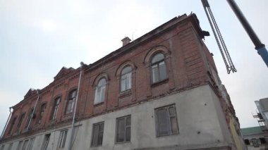 Crane, eski ve yeni arasındaki zıtlığı ortaya çıkarmak için yıkılan duvarların yanında çalışıyor. Koruma süreci tarih mimarisini ve değerli kimliğini kurtarır