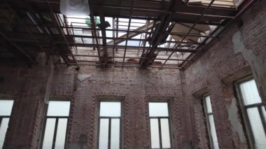 Kısmen sökülmüş antik bina, kırılgan kirişleri ortaya çıkarıyor. Açık gökyüzü ufalanan yapının üstündeki boşluğu iskelet ahşap çerçeveyle doldurur