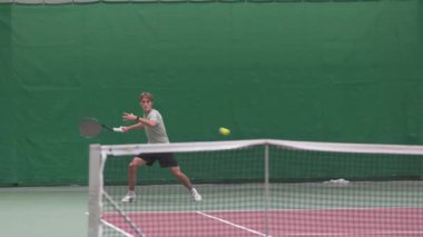 ALMATY, KAZAKHSTAN - 08 Nisan 2025: Genç tenisçi keskin servis ile sahada hızla ilerliyor. Dinamik ralli hız tekniğini, dayanıklılığı ve keskin doğruluğu vurguluyor