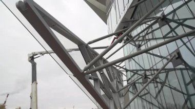 Arka perspektif, demir örgüyle zenginleştirilmiş cam parçalarını ortaya çıkarıyor. Mimari tasarım gelecekteki endüstriyel atmosferi gösteriyor