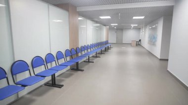 Koridor beyaz duvarlar ve mavi sandalyelerle parıldıyor. Okyanus görüntüsü otururken cazibe ekler. Uyum ile birlikte işlevselliği de vurgular.