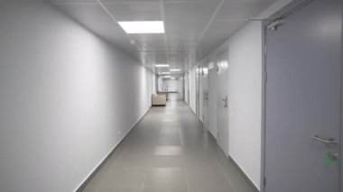 Uzun bej renkli koridor karşı ofislerde yumuşak kanepelerle uzanıyor. Lüks denge ve disiplinle dolu özel klinik atmosferi