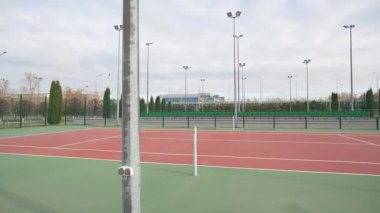 Modern stadyum, asfalt rayları ve yeşil çimlerle geniş bir alana yayılır. Çeşitli spor aktiviteleri için düzgünce kırpılmış çimenlik çevre bölgeleri