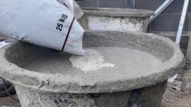 Kapatın. Elektrikli mikser kullanarak betonu karıştırma çekimi. İşçi havanı karıştırır.