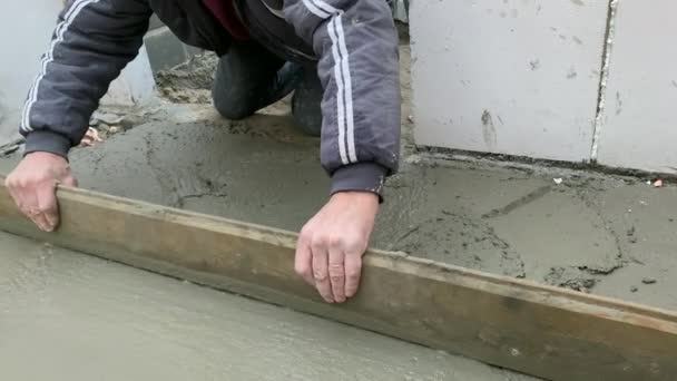 鉄筋コンクリートの床のコンクリート 作業者コンクリート床補強メッシュにセメントモルタルを注ぎます — ストック動画